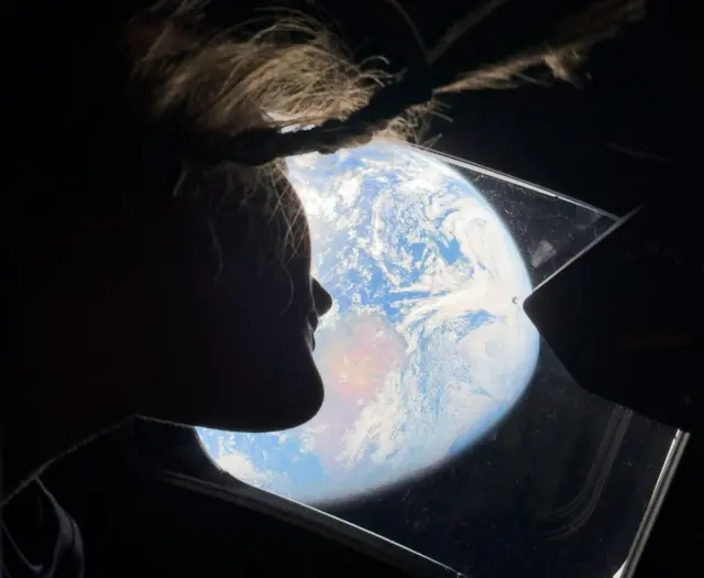 Astronọtụ n'ụlọọrụ NASA bụ Christina Koch bụ Ọkachamara mgbasaozi Artemis II ndị ọgbọ si n'otu n'ime windo ụlọ nke Orion na Satọde, Eprel 4, 2026, na-eleghachi anya n'ụwa, ka ndị ji igwe 'Artemis II' gaa n'ihu ọnwa.