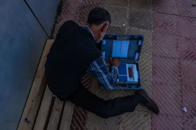 ईव्हीएम चेक करणारे एक पोलिंग ऑफिसर