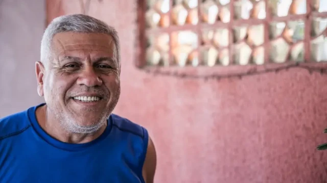 Homemcabelo branco e camisa azul sorri