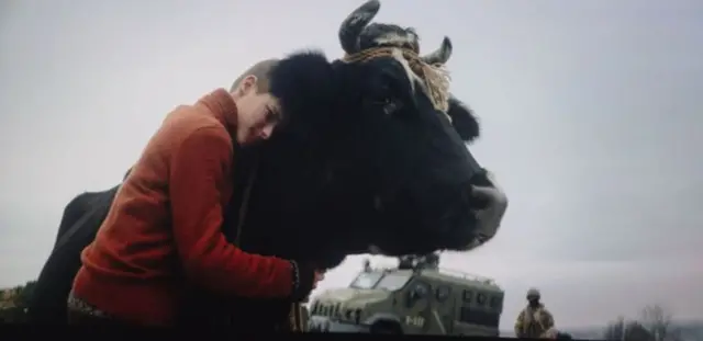 Хлопчик обіймає корову за шию