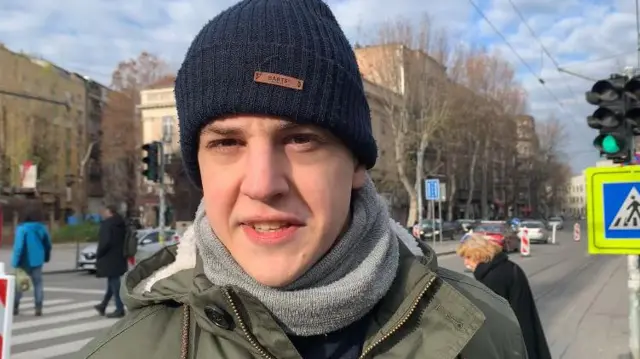 student Marko bojović nosi crnu kapu na glavi, sivi šal i zelenu jaknu 