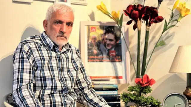 داوود سیاووش در کنار تصویری از فرزندش یما سیاووش