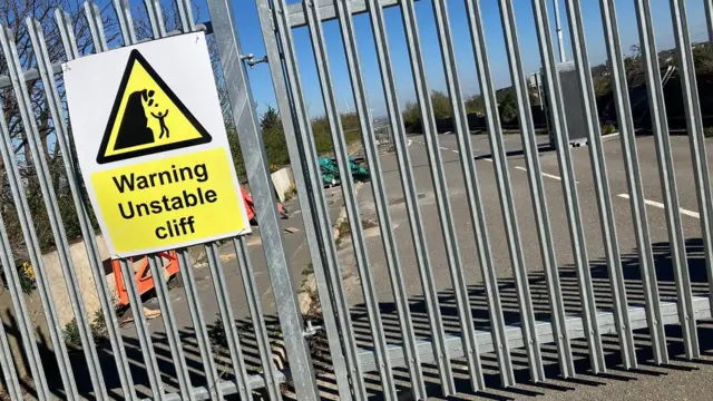 Una valla que bloquea el acceso a una carretera.