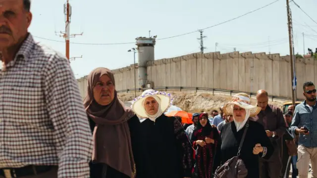 Palestinos cruzam posto de controle de Qalandiya, ao sul de Ramallah, Cisjordânia