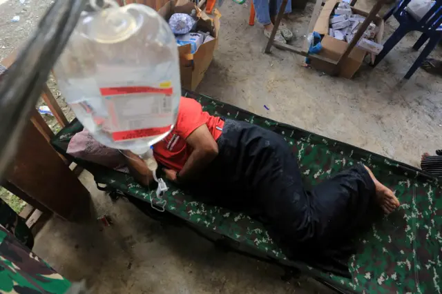 Salah satu korban banjir menjalani perawat medis di Desa Blang Meurandeh, Beutong Ateuh Banggalang, Nagan Raya, Aceh, Minggu (30/11/2025). Meskipun stok obat-obatan menipis namun petugas kesehatan tetap melayani warga korban banjir yang didominasi lansia dan anak-anak yang mayoritas terserang penyakit pilek, batuk, demam, gatal-gatal, kaki kesemutan dan tekanan darah tinggi (hipertensi). 