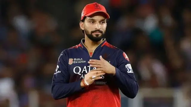 රජත් පටිදාර් RCB කණ්ඩායමේ නිල ඇඳුමෙන් සැරසී ක්‍රීඩා පිටියේ සිටින අයුරු.