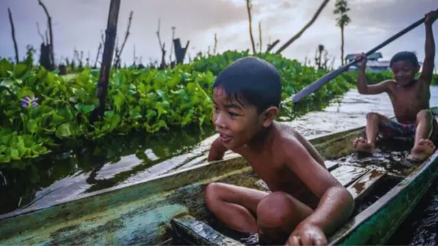 મનોબા સમુદાયનાં બાળકો તેમની તરતી શાળામાં અભ્યાસ પછી તેમનાં માતાપિતાની પરંપરાગત નાવડીઓમાં રમે છે