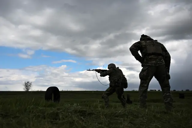 Військові з автоматами на полі