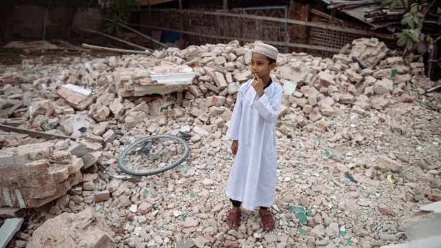 Un niño musulmán permanece de pie sobre los escombros de un edificio derrumbado en Mandalay el 31 de marzo de 2025, tres días después del mortífero terremoto de Myanmar.