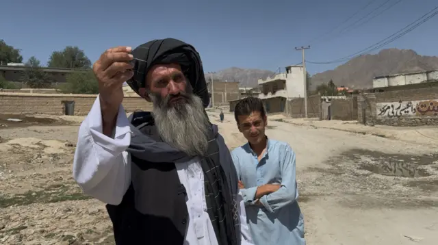 یو سپينږيری کس چې افغاني جامې یې په تن دي