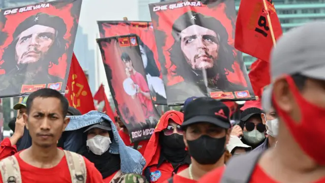 Para pengunjuk rasa memegang spanduk dan bendera yang memuat potret Che Guevara saat mengikuti aksi Hari Buruh di Jakarta, Senin (01/05). 