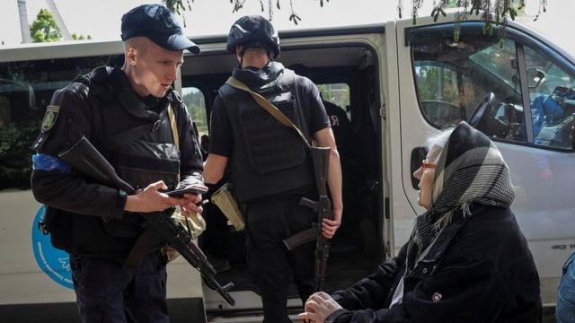 Un oficial de policía ayuda a un residente local durante una evacuación en Vovchansk.