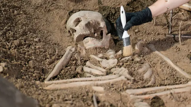 یو د انسان هډوکي (کالبد) چې له ځمکې څخه د برش په مرسته رایستل کېږي.