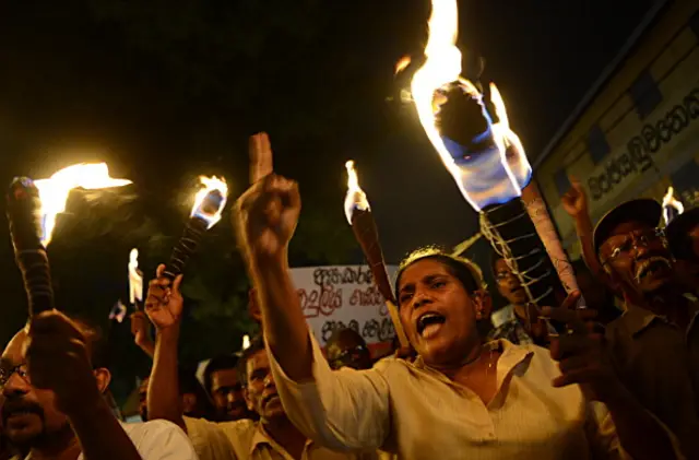 Activists from the Sri Lankan People's Liberation Front (JVP), the country's main Marxist party, carry lit torches as they protest against electricty tariff hikes in the Colombo suburb of Maharagama on April 22, 2013. Sri Lanka's state-run electricity monopoly last week hiked rates by as much as 65 percent as part of plans to reduce huge losses in a country which is already one of the most expensive in Asia for electricity. AFP PHOTO/Ishara S. KODIKARA