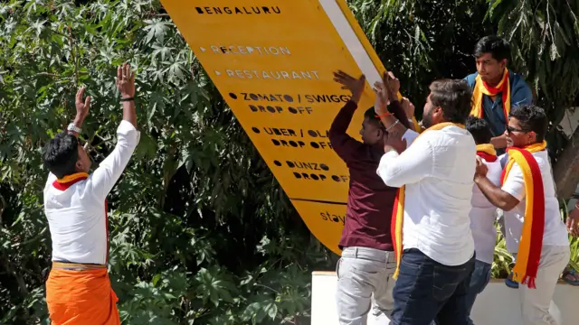 बेंगलुरु में अंग्रेजी में लिखे बोर्ड को तोड़ता केआरवी का एक कार्यकर्ता