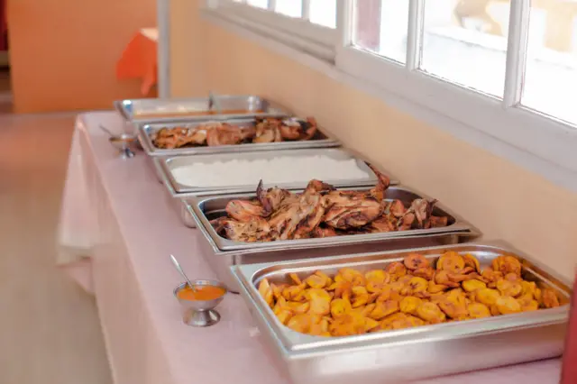 Un buffet africain avec poulets, bananes plantain et riz
