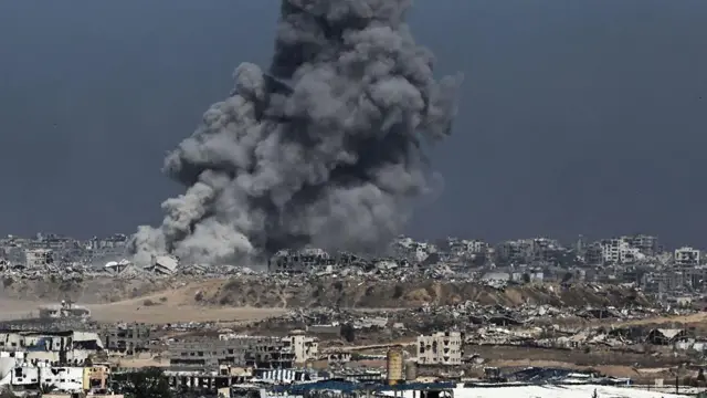 Una columna de humo se levanta entre los escombros de Gaza tras otro ataque israelí.