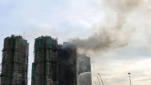 2025年11月27日，香港大埔區屋苑住宅發生大火，多棟公寓大樓被燒毀，消防員用水槍撲滅火焰。