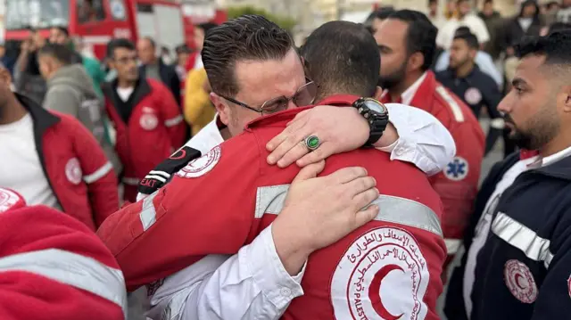 Filistin Kızılayı çalışanları, meslektaşlarının cenazelerinin Gazze'nin güneyindeki Han Yunus'taki bir sağlık tesisine getirilmesi sırasında kucaklaşıyor
