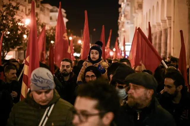 Много мрачных людей с красными флагами