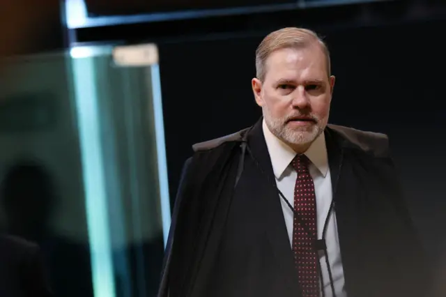 Ministro Dias Tofolli usando a toga e caminhando com