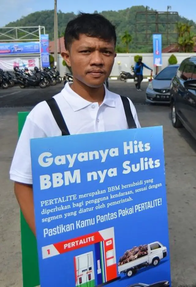 Petugas membawa poster di badannnya saat sosialisasi subsidi tepat pertalite di SPBU Coco Mata Air Padang, Sumatera Barat, Kamis (1/8/2024). 