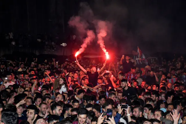 Trabzonspor taraftarları, Mısırlı futbolcu Mohamed Salah'ın gelişini beklerken 5 Ağustos 2026 tarihinde Trabzon kentindeki havaalanı dışında meşaleler yakıyor.