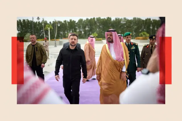 Perezida Volodymyr Zelenskiy wa Ukraine ari kumwe n'abategetsi ba Arabia Sawudite mu rugendo rwiwe i Jeddah ku wa 26 Ntwarante (3), 2026. Zelensky yambaye impuzu zirabura.