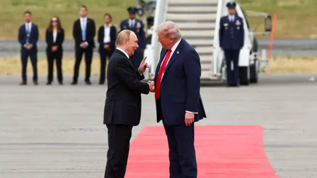 Putin e Trump apertam as mãos