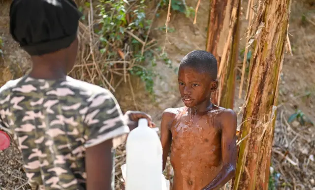 Seorang anak mandi di kawasan Petion-ville di Port-au-Prince, Haiti