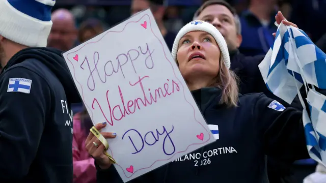 Болельщица сборной Финляндии держит плакат с поздравлениями ко Дню святого Валентина