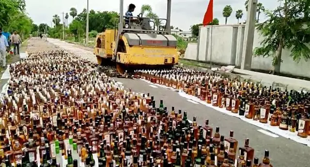 a bulldozer mauling fake alcohol bottles seized by authoriets