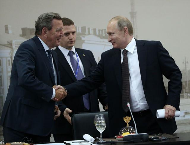 Schröerder le estrecha la mano a Putin