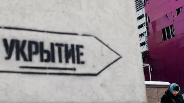 Знак «Укрытие» рядом с домом, поврежденным из-за обстрела