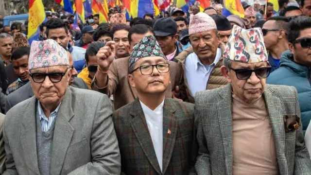 राप्रपाका नेताहरू प्रकाश चन्द्र लोहनी, राजेन्द्र लिङ्देन र पशुपति शमशेर राणा एउटा प्रदर्शनमा झन्डा बोकेका कार्यकर्ताहरू माझ। 