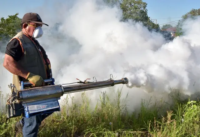 Homem aplicando fumacê contra mosquitos