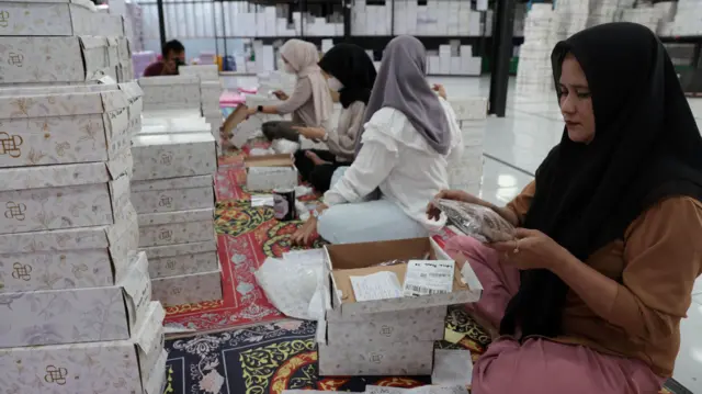 Para pekerja mengemasi sepatu dan tas di pabrik sepatu dan tas wanita Patris di Bogor, Indonesia, 14 April 2025. Pabrik sepatu Patris mengelola sekitar 10 Usaha Mikro, Kecil, dan Menengah (UMKM) dengan sekitar 300 pekerja UMKM. Pabrik ini mengandalkan platform daring untuk menjual produknya ke berbagai negara, termasuk Amerika Serikat. Alas kaki merupakan komoditas ekspor terbesar ketiga Indonesia ke Amerika Serikat.