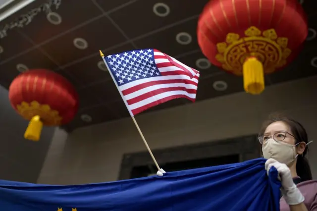 一位华人面孔的女士挥舞美国国旗
