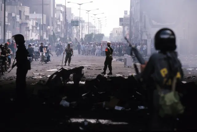 Aparat bersenjata terlihat berjaga di salah satu sudut Jakarta saat kerusuhan Mei 1998.