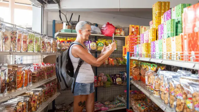 Mujer tomando una foto en un supermercado 