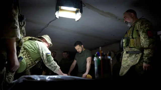 Le président ukrainien Volodymyr Zelenskiy regarde une carte et écoute un rapport des commandants alors qu'il visite une position près de la ligne de front, au milieu de l'attaque russe contre l'Ukraine, dans la région de Donetsk, en Ukraine, le 26 juin 2023.
