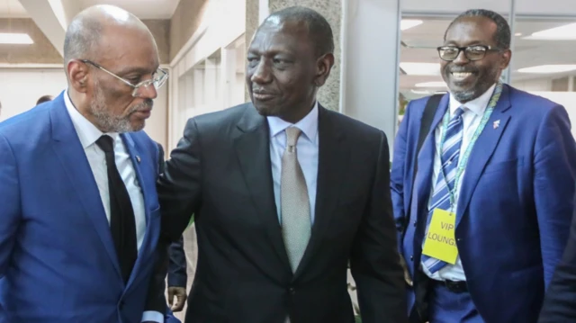 Perdana Menteri Haiti Ariel Henry (kiri) berjalan bersama Presiden Kenya Willam Ruto (tengah) dalam sebuah pertemuan di Nairobi, Kenya, pada 29 Februari 2024.