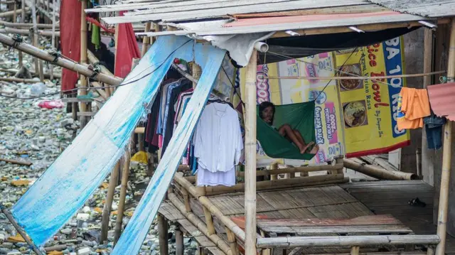 Seorang anak menaiki ayunan kain di kawasan permukiman kumuh di Kosambi, Kabupaten Tangerang, Banten, Selasa (10/6/2025).