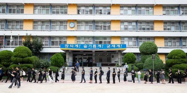 많은 사람들이 사망한 서이초 교사의 49재 추모제에 참석하기 위해 학교 앞에 길게 줄을 서 있다.