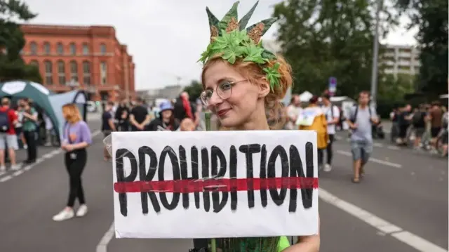 mulher com placa pedindo liberação da maconha