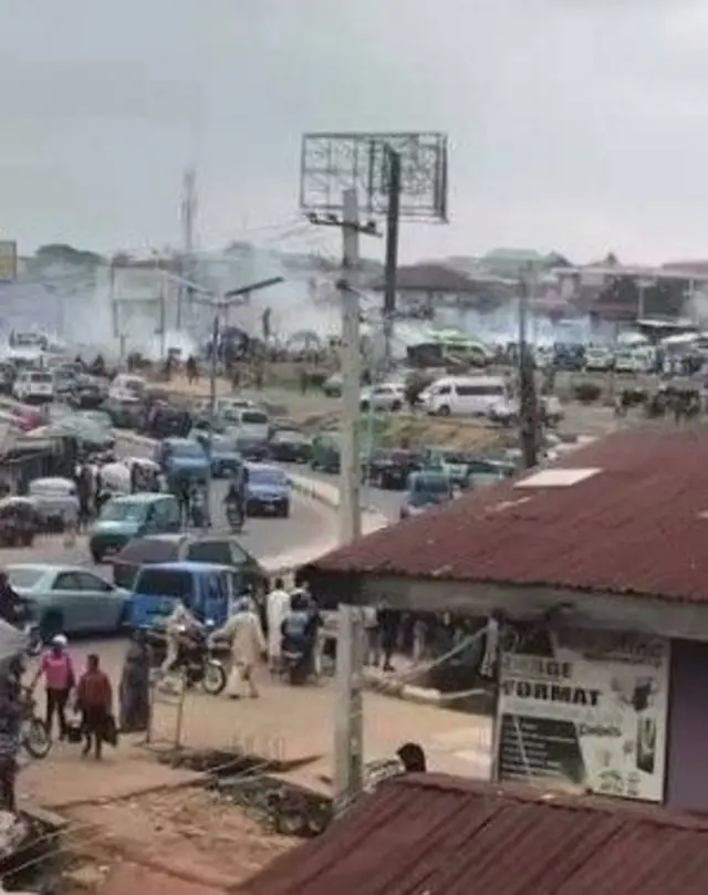 Adugbo kan ti awọn eeyan n rin kọja, ọkọ n lọ loju popo amọ eefin wa loju ofurufu
