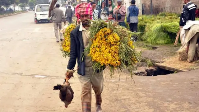 ገልገለ መስቀል ብሓደ ኢዱ ብኻልእ ኢዱ ድማ ደርሆ ዘንጠልጠለ ሰብኣይ።