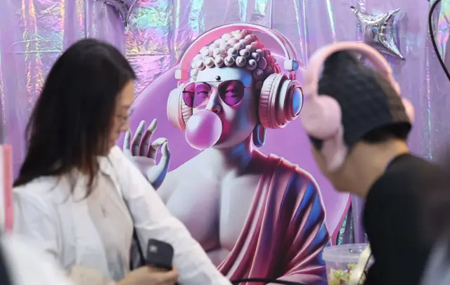 지난 4월 서울국제불교박람회에서 파티인붓다 부스를 찾은 관람객이 굿즈를 구입하고 있다. 뒤로는 헤드셋과 선글라스를 쓰고 풍선껌을 불고 있는 부처의 그림이 보인다