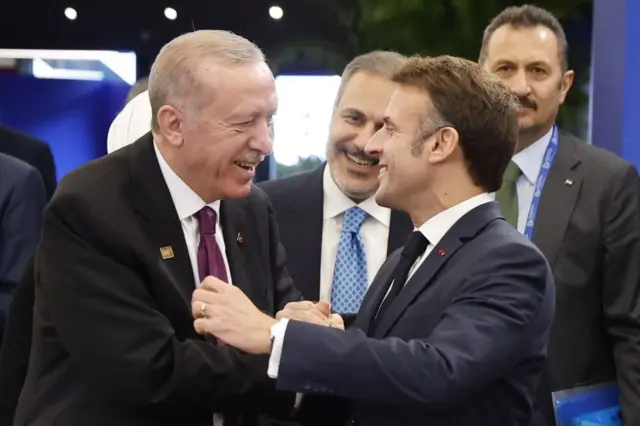Cumhurbaşkanı Recep Tayyip Erdoğan ve Fransa Cumhurbaşkanı Emmanuel Macron 7 Kasım 2024’te Budapeşte’de düzenlenen Avrupa Siyasi Topluluğu Zirvesi kapsamında gerçekleştirilen yuvarlak masa toplantısı öncesinde gülüşürken.
