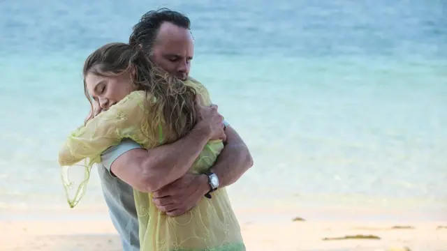 Los protagonistas de esta temporada de White Lotus Walton Goggins y Aimee Lou Wood se abrazan.